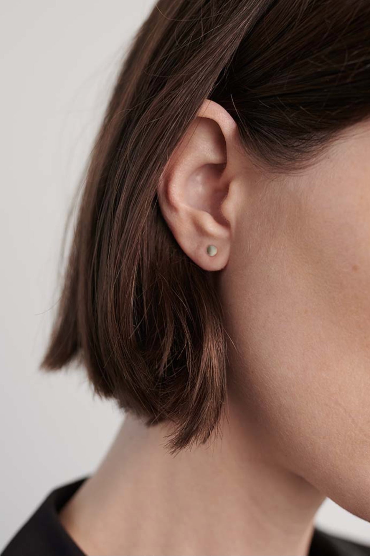 Model wearing gold disc stud earrings styled for everyday minimalist look.