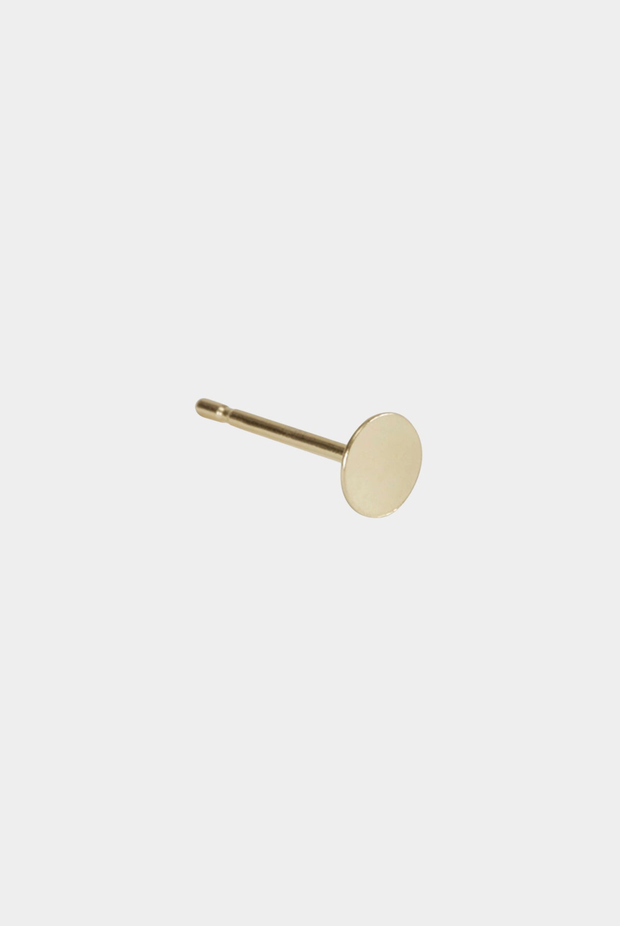 Medium gold disc stud earring with polished post and matte surface.