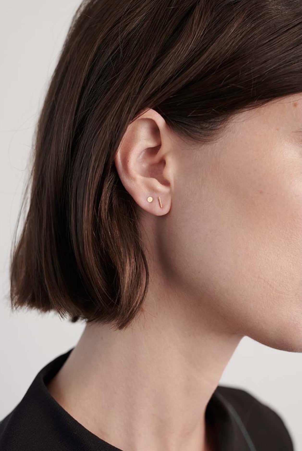 Model wearing delicate 14K gold T-bar stud earring.