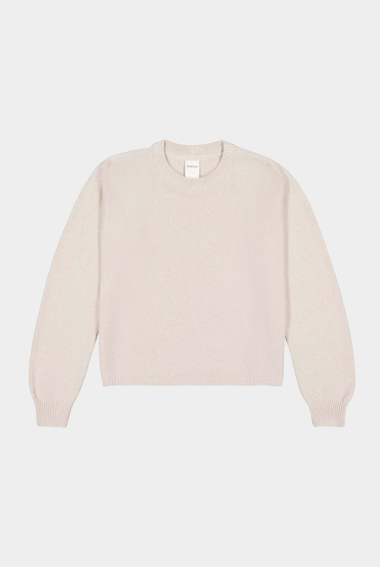 Flat lay of cream textured crewneck sweater with ribbed neckline, cuffs, and hem.