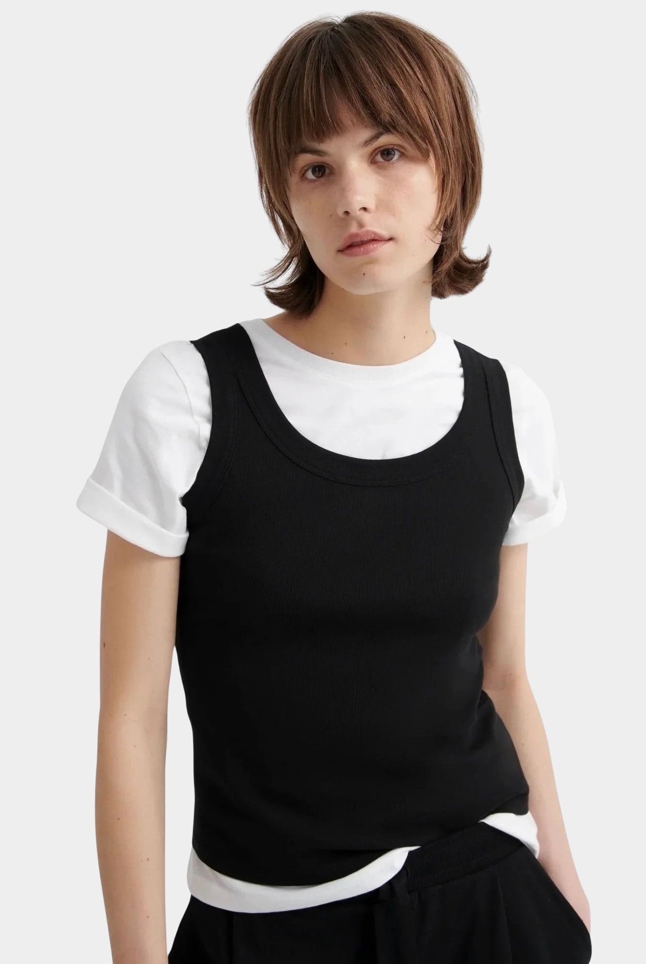 Kowtow Everyday Tank in black layered over white t shirt, close up front view