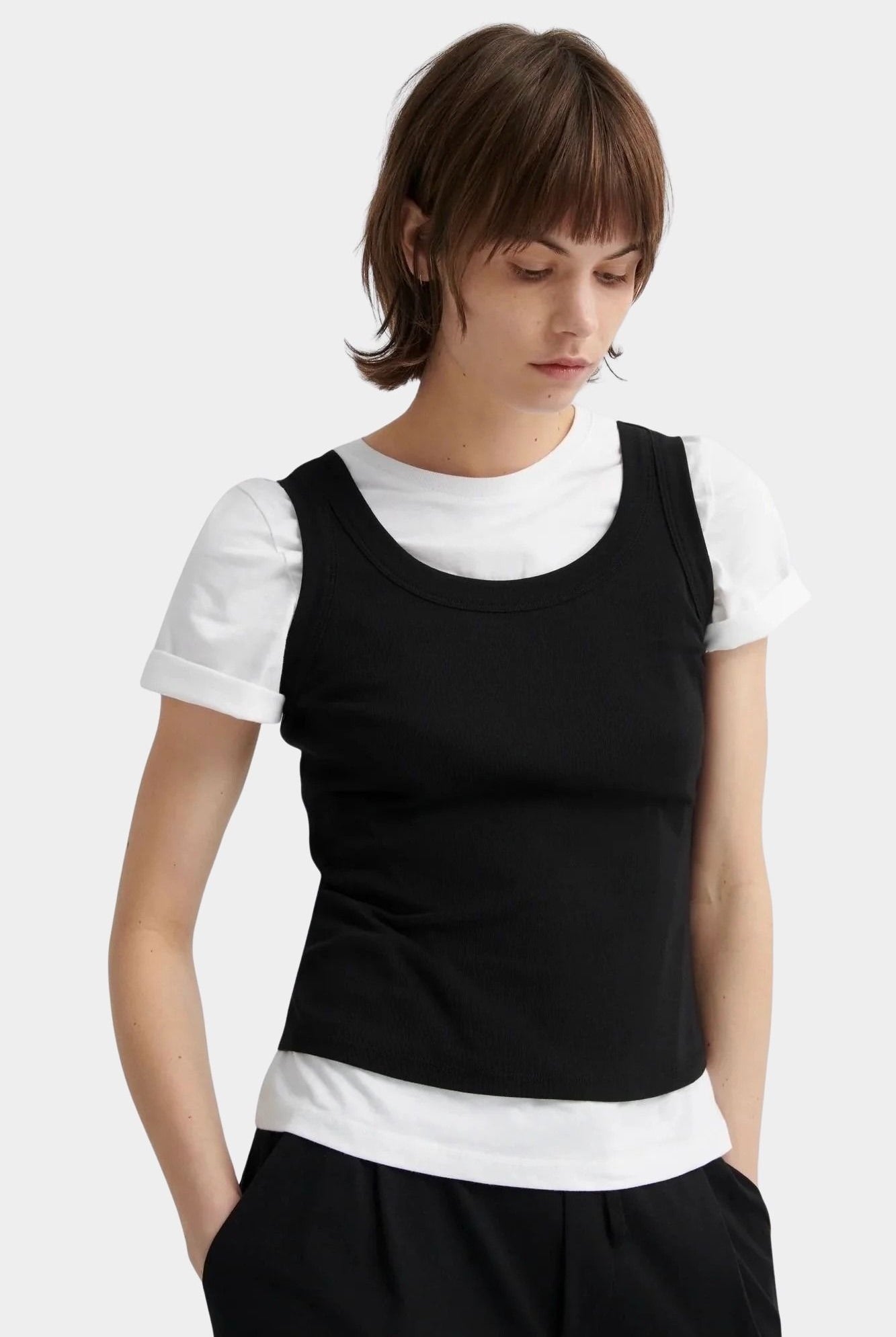 Kowtow Everyday Tank in black layered over white t shirt, front view