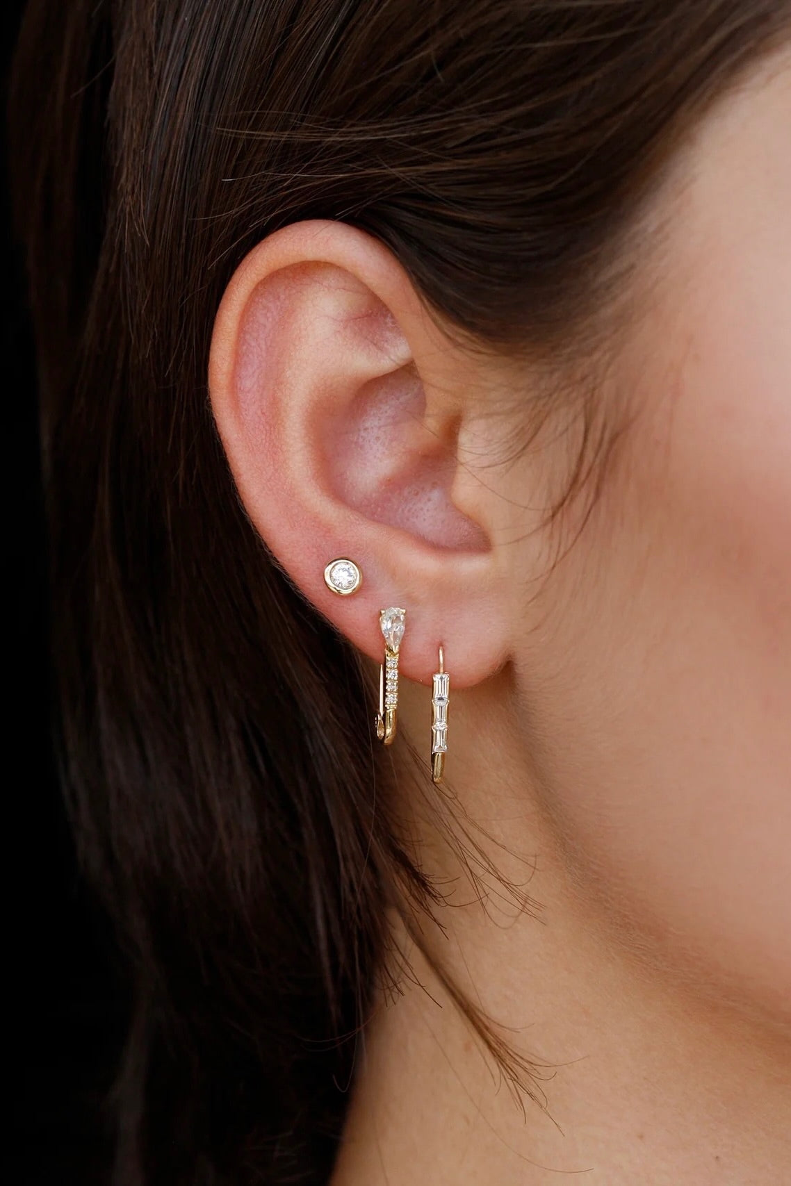 Model wearing 14K gold diamond and sapphire drop hoop earrings.