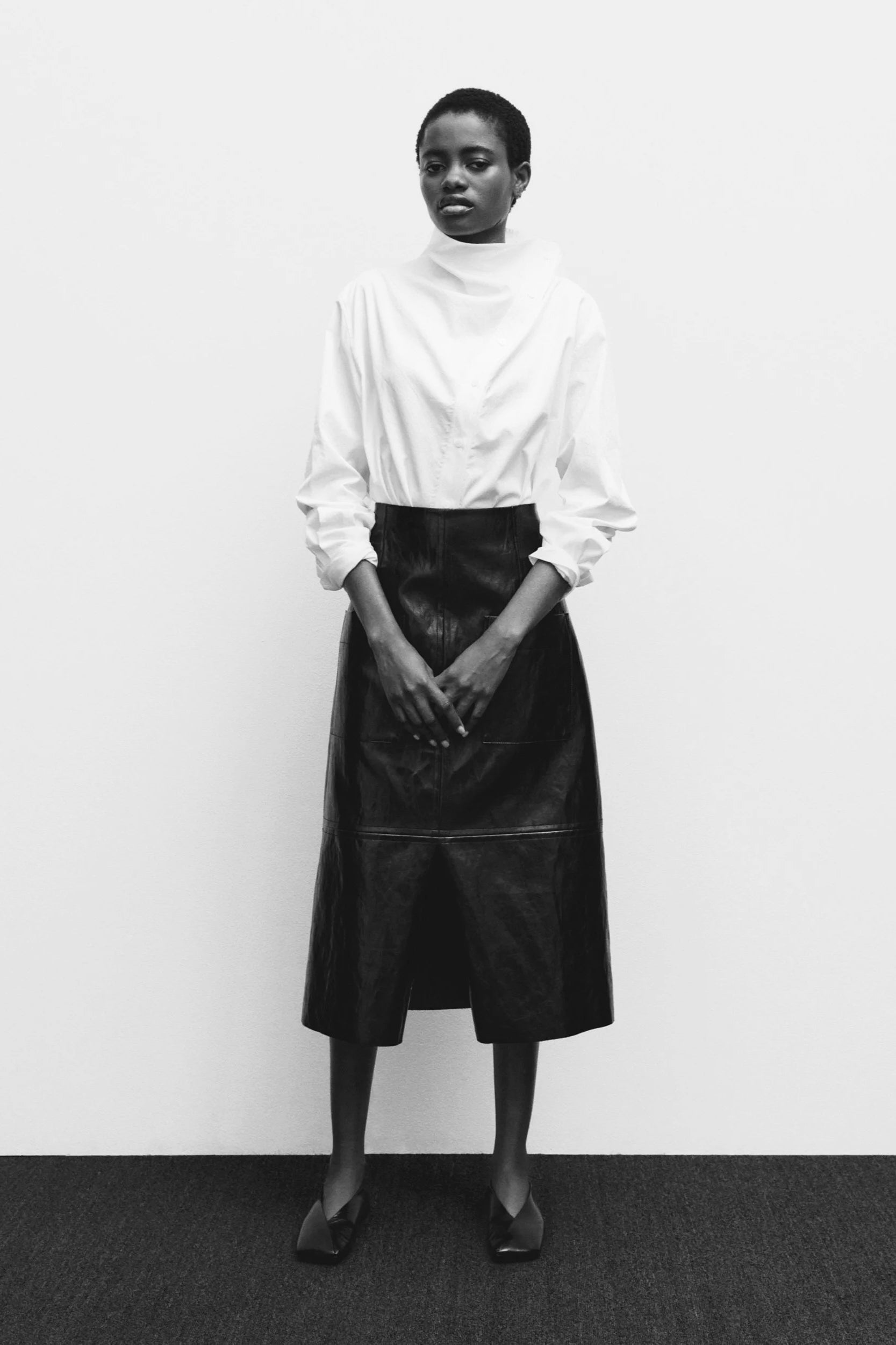 Minimal black midi skirt styled with white blouse, modern women’s skirt collection at YUCCA Denver