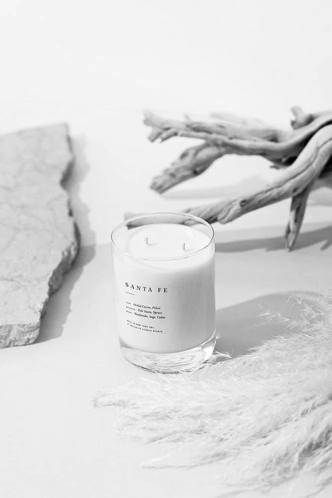 Brooklyn Candle Studio soy candle styled with driftwood and textured neutrals in a minimalist home setting