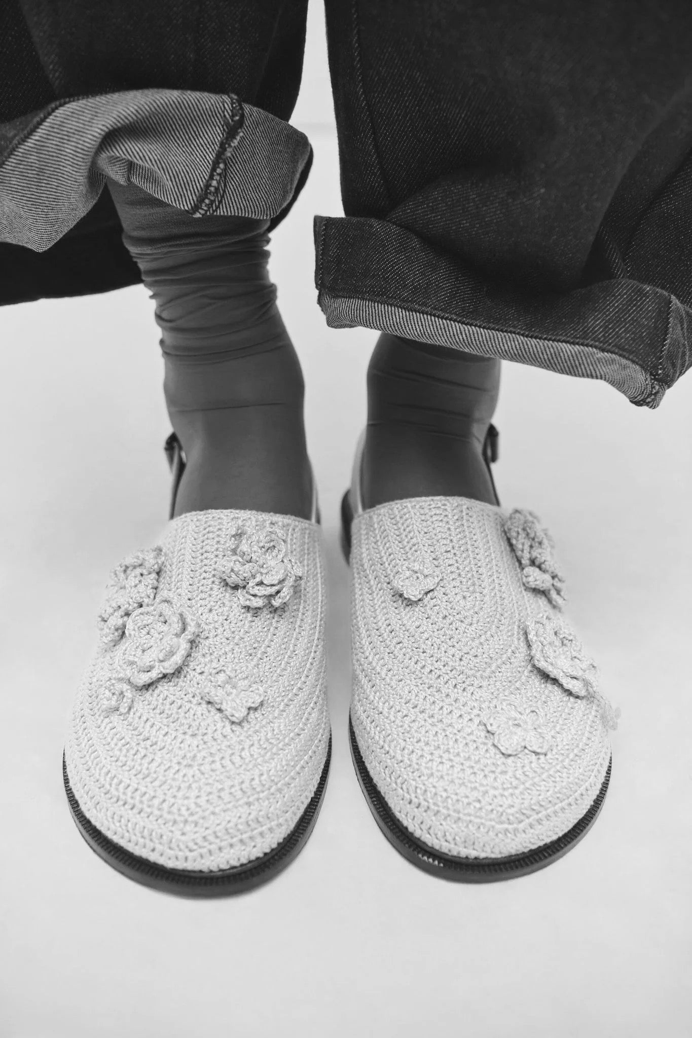 Woman wearing leather mules with cropped denim, detail of modern footwear styling