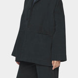 7115 by Szeki oversized cotton twill blazer charcoal black relaxed fit drop shoulder button front workwear jacket angled front view
