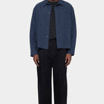 Front view of the navy 7115 by Szeki Relaxed Pocket Shirt worn open over a black tee at YUCCA Denver
