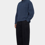 Angled front view of the navy Relaxed Pocket Shirt buttoned with black wide leg trousers