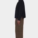 Side view of the black Relaxed Pocket Sweater showing the slit at the hem