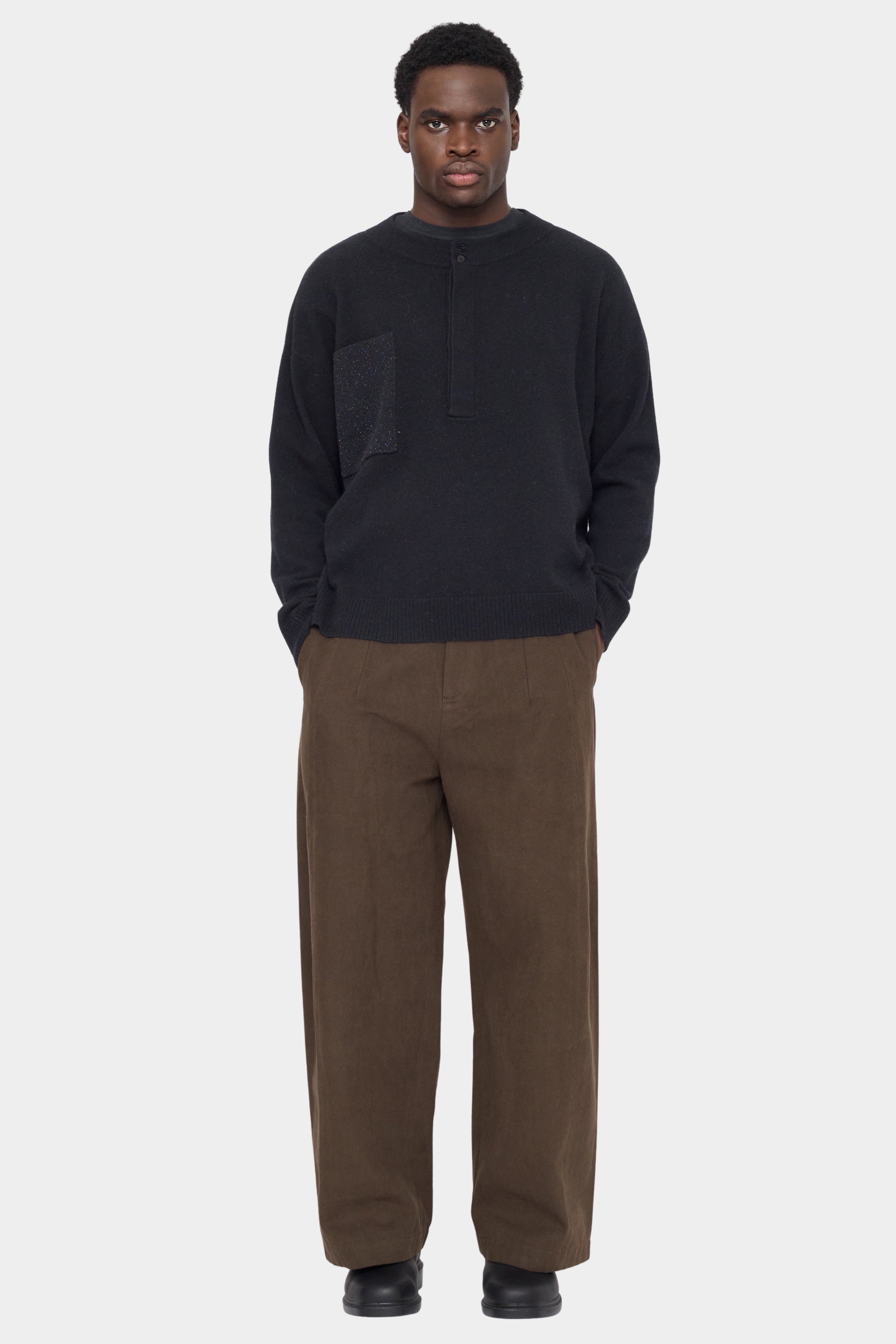Front view of the black 7115 by Szeki Relaxed Pocket Sweater with brown trousers at YUCCA Denver