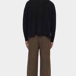 Back view of the black Relaxed Pocket Sweater showing its dropped shoulders and relaxed shape