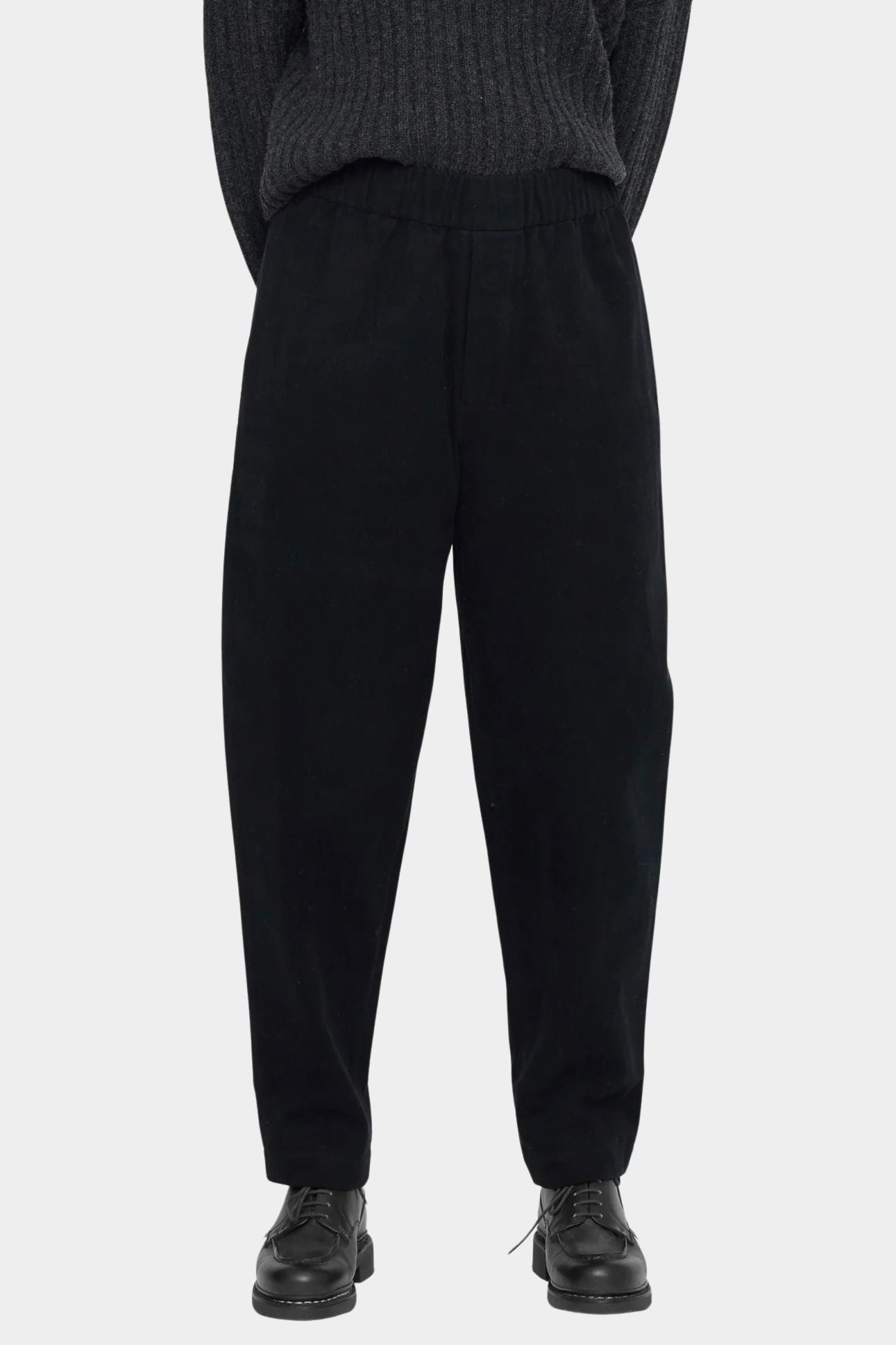 Close front view of the black pull-up trouser showing the elastic waist and softly tapered legs