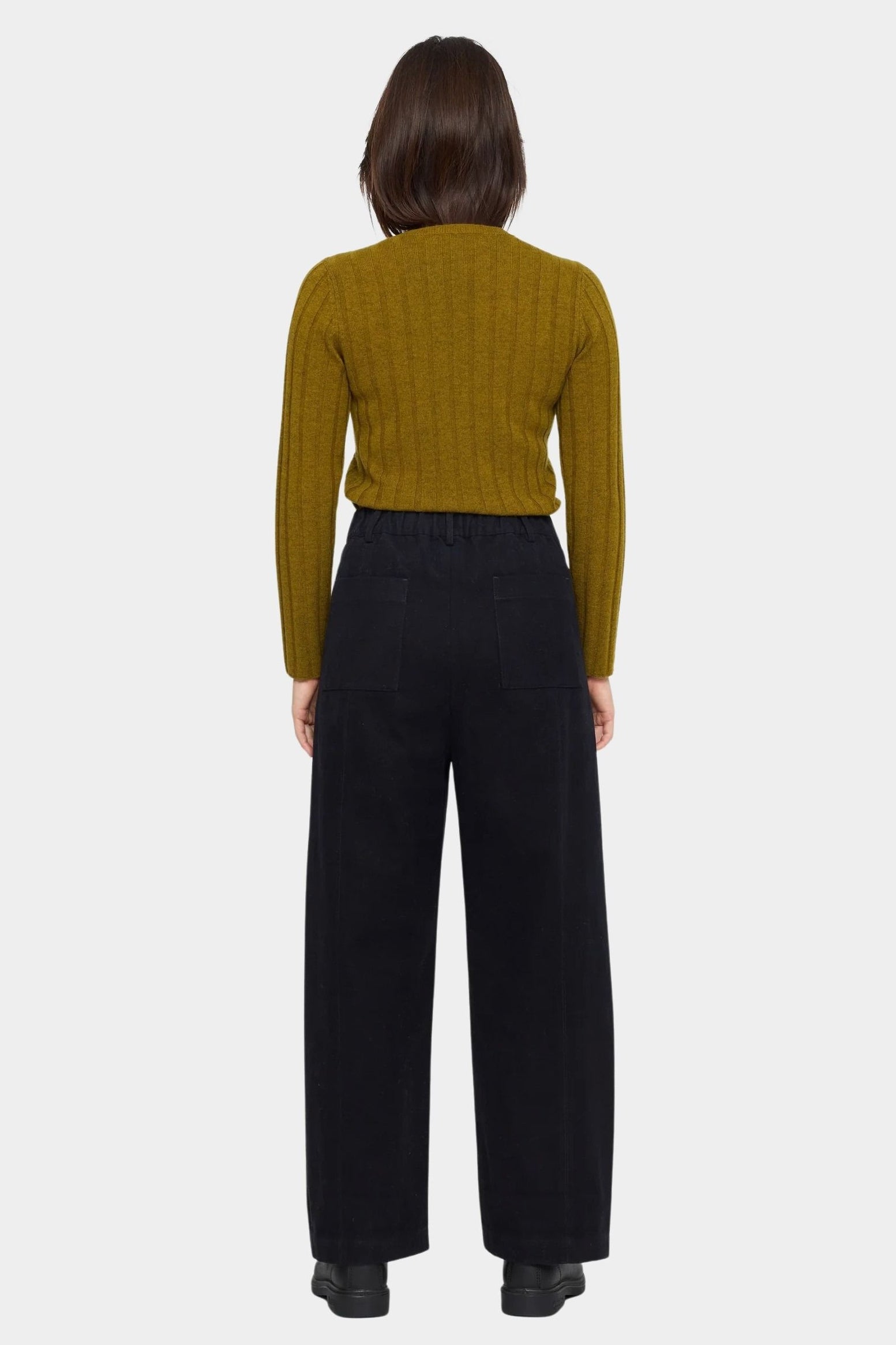Back view of the black straight legged trouser showing its elastic waist and two patch pockets