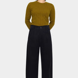 Black straight legged trouser styled with an olive ribbed sweater, showing the clean front waistband
