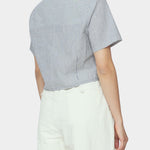 Back and side close up of navy striped cropped shirt with short sleeves and back yoke styled with ivory trousers