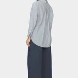 Back and side view of navy striped dolman shirt with split collar, inverted box pleat, and rounded high low hem