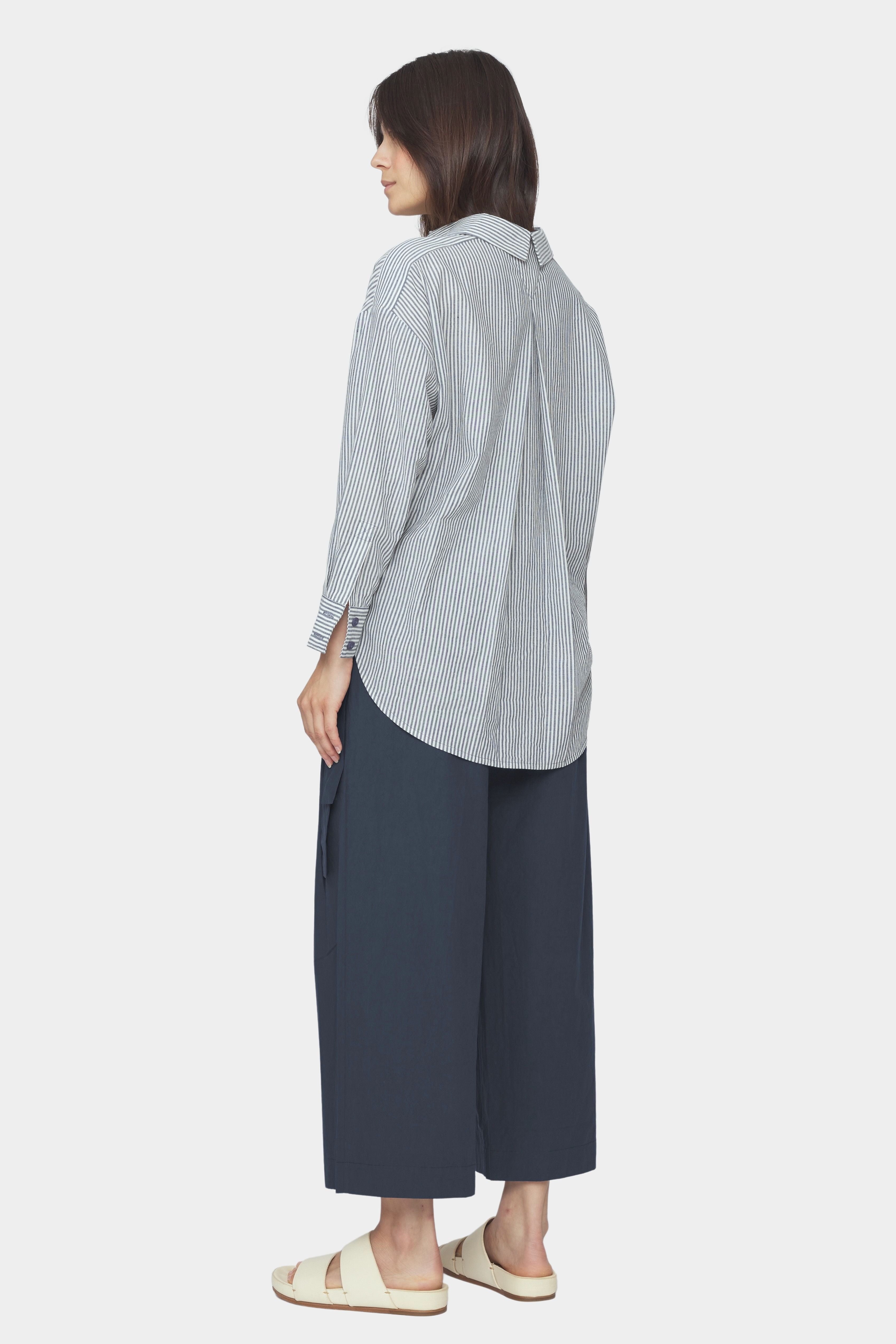 Back and side view of navy striped dolman shirt with split collar, inverted box pleat, and rounded high low hem