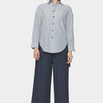 Front view of navy striped dolman shirt with relaxed fit, dropped shoulders, and rounded hem styled with wide leg navy pants