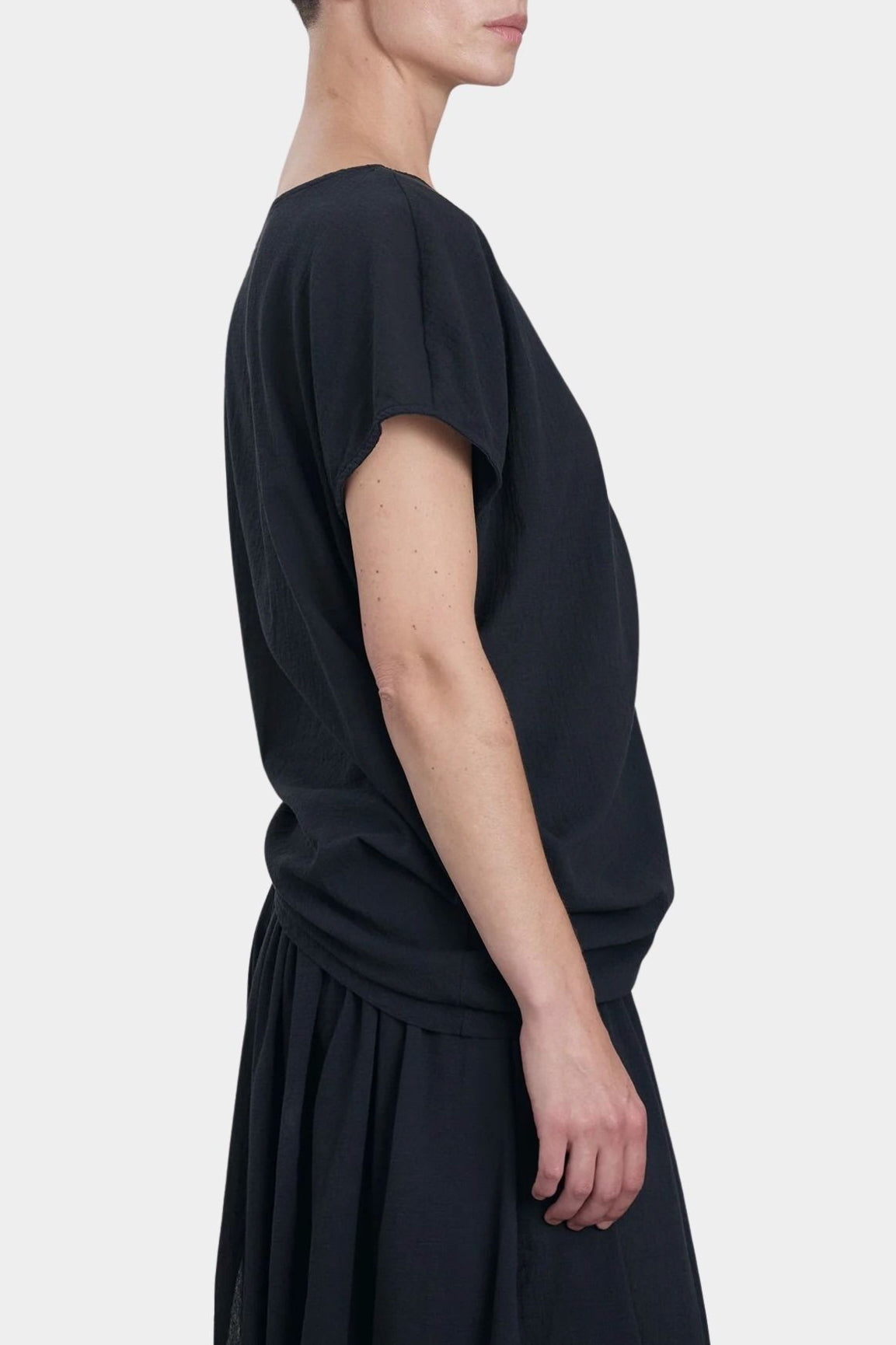 Black Crane asymmetric cotton gauze top sumi black angled side view showing drape and sleeve shape