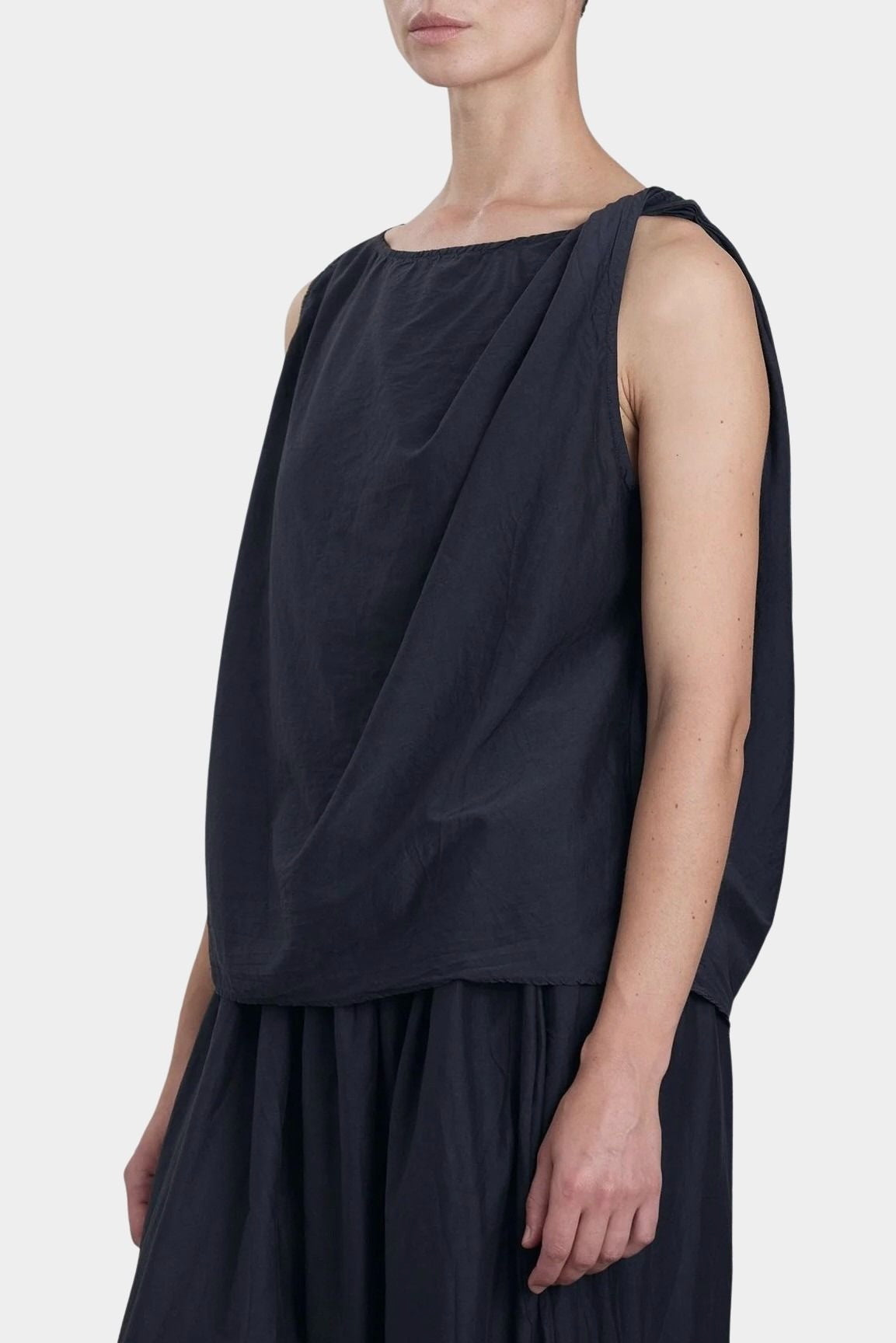 Black Crane faded black twisted tank top side view with asymmetric drape and relaxed silhouette