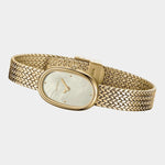 Angled side view of BREDA Jane Tethered gold watch showing oval case, textured bracelet and clasp