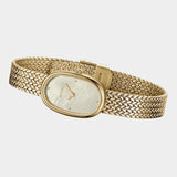 Angled side view of BREDA Jane Tethered gold watch showing oval case, textured bracelet and clasp