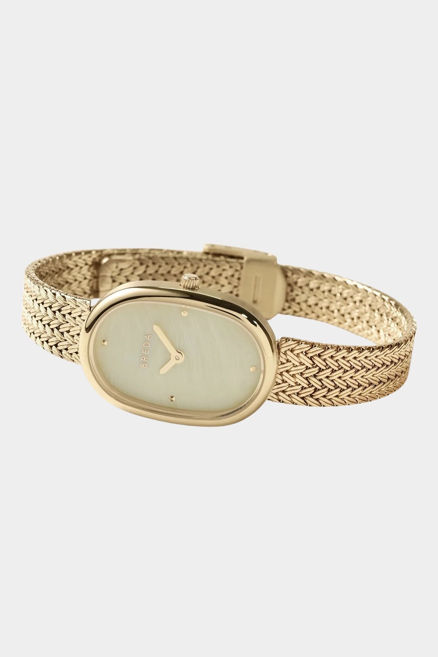BREDA Jane Tethered gold watch with curved woven bracelet and visible clasp on a light gray background