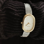 BREDA Jane Tethered gold and silver watch styled over dark textured knit fabric
