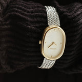 BREDA Jane Tethered gold and silver watch styled over dark textured knit fabric