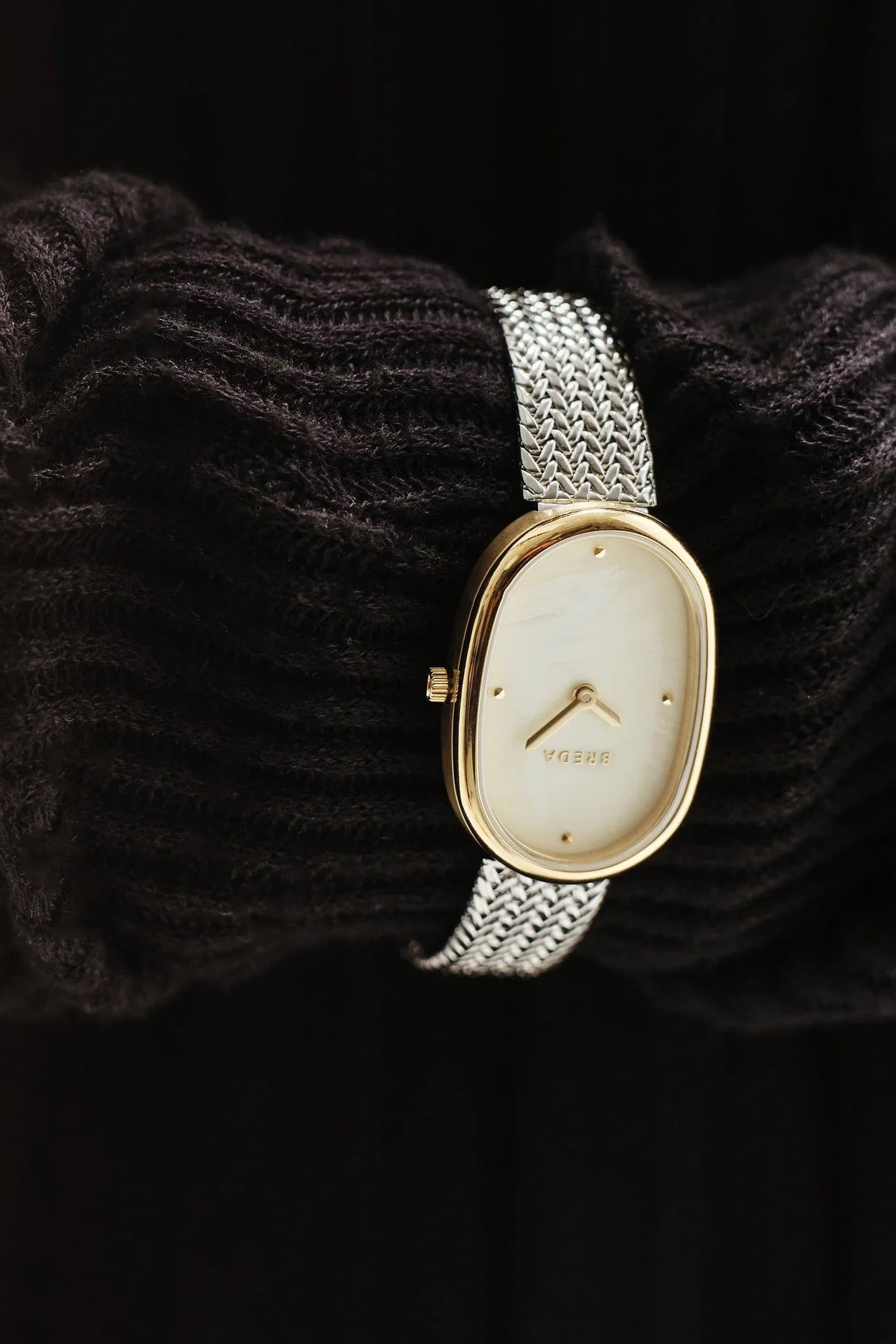 BREDA Jane Tethered gold and silver watch styled over dark textured knit fabric