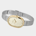 Angled view of BREDA Jane Tethered watch showing gold plated oval case and woven silver stainless steel bracelet