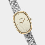 BREDA Jane Tethered watch with gold oval case, mother of pearl dial and woven silver bracelet at YUCCA Denver