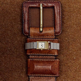 BREDA Revel square face watch styled across a vintage brown leather belt on textured fabric