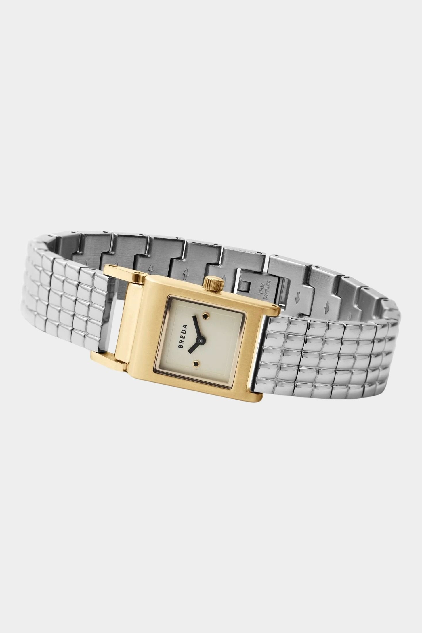 BREDA Revel two tone watch with curved silver bracelet, gold case and jewelry clasp on light gray background