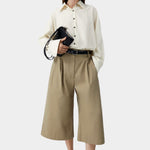 Camel cotton capri pants worn with button-down shirt and sandals