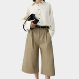 Camel cotton capri pants worn with button-down shirt and sandals