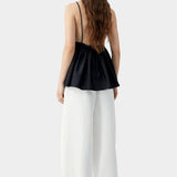 Black camisole top with thin straps, gathered back, and soft drape