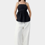 Black embroidered camisole top with relaxed silhouette, worn with white trousers