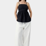 Black embroidered camisole top with relaxed silhouette, worn with white trousers