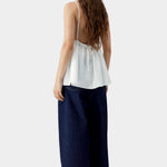 White camisole top with thin straps, gathered back with tie detail, and soft drape