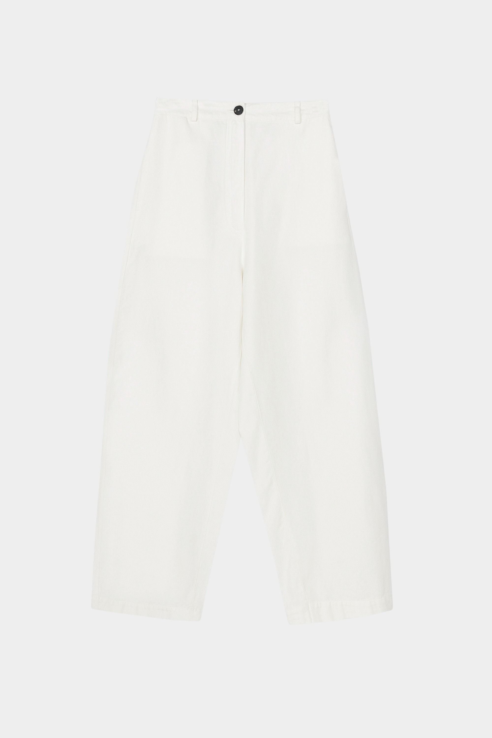White cotton linen curved leg pants with front closure, belt loops, and softly structured silhouette