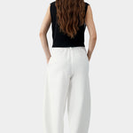 White cotton linen curved leg pants with elastic waistband and relaxed tapered silhouette, back view