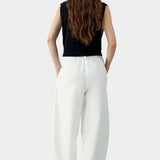 White cotton linen curved leg pants with elastic waistband and relaxed tapered silhouette, back view