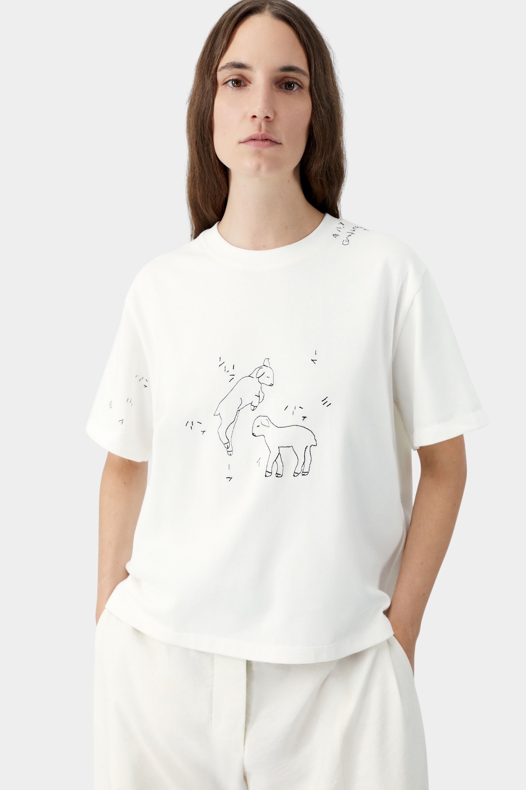White embroidered t-shirt with relaxed fit and short sleeves, worn with matching trousers