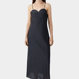 Black midi dress with heart-shaped neckline and slim straps, worn with flat sandals and fluid silhouette