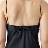 Black heart-shaped dress with thin straps and elastic back panel, showing gathered detail and lightweight texture