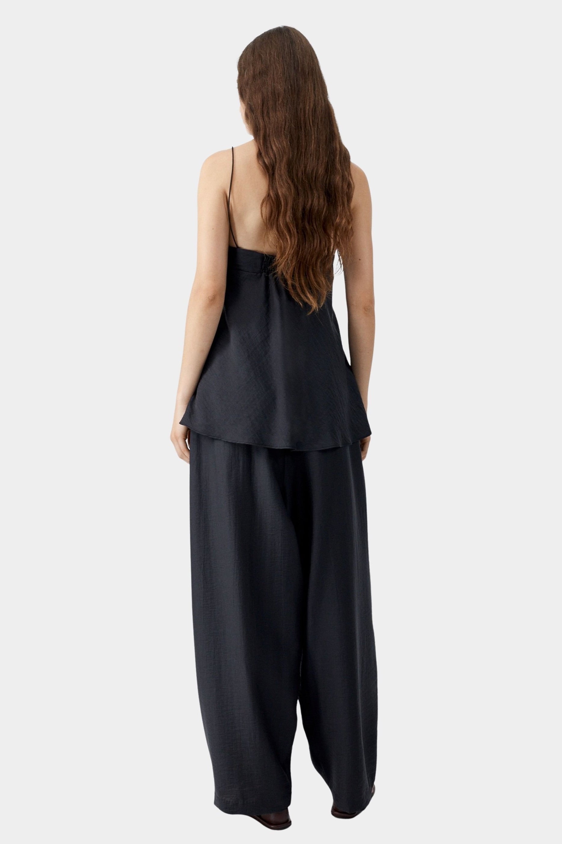 Black camisole top with thin straps, soft back drape, and relaxed silhouette