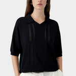 Black knit polo top with collar, V neckline, and sheer vertical lace panel detailing
