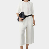Cream lace panel polo top worn with matching wide leg cropped trousers and sandals